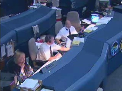 Lo space shuttle flight director Tony Ceccacci e il Capcom Steve Robinson, astronauta della STS-114, sono alle loro postazioni nella ISSFCR assieme a una donna bionda che ho appurato si chiama Rebecca, la quale ha conversato parecchi minuti col comandante dello shuttle, ma della quale non ho altre notizie: 18 KB
