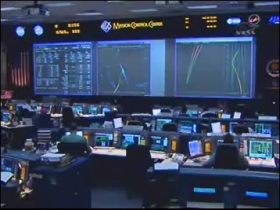 Il grande schermo triplo di Mission Control a Houston mostra i dati dello shuttle, la rotta e la posizione geografica, il grafico di rientro: 35 KB