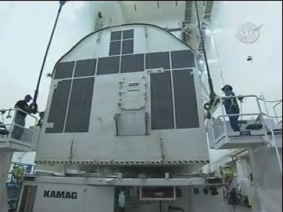 Il 'contenitore' di Kibo viene sollevato e agadiato sul pianale del mezzo che lo trasporterà alla rampa di lancio: 29 KB